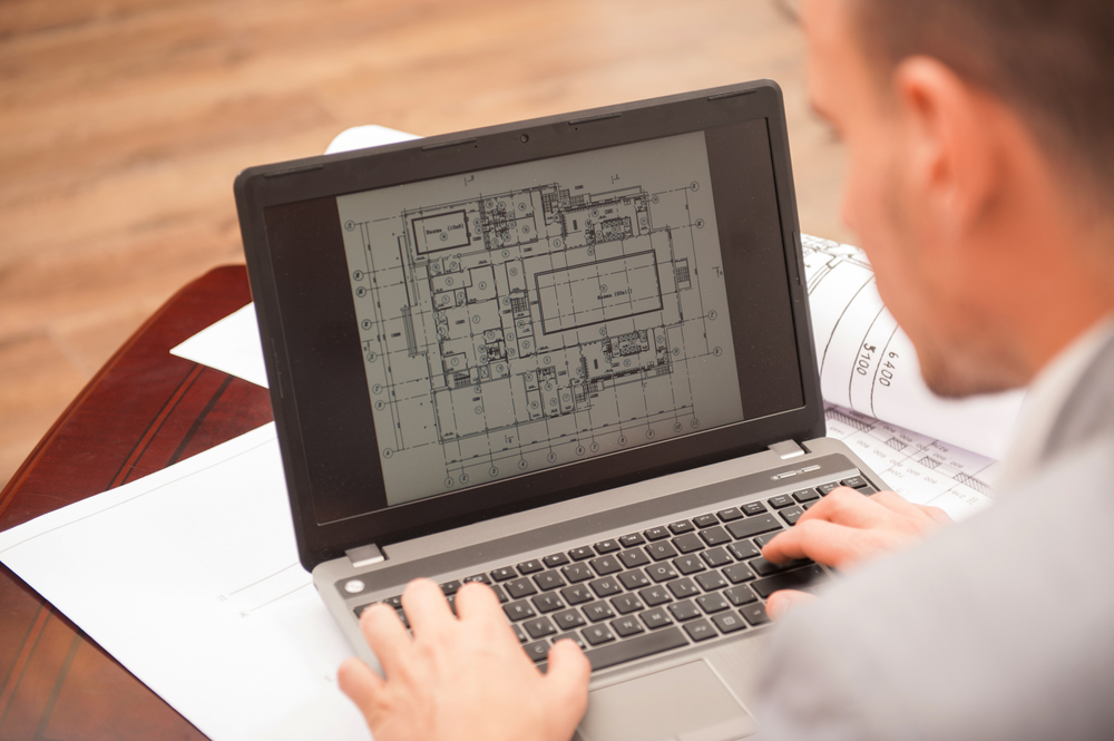 Close Up,portrait,of,laptop,with,blueprints,,architect,sitting,from,behind