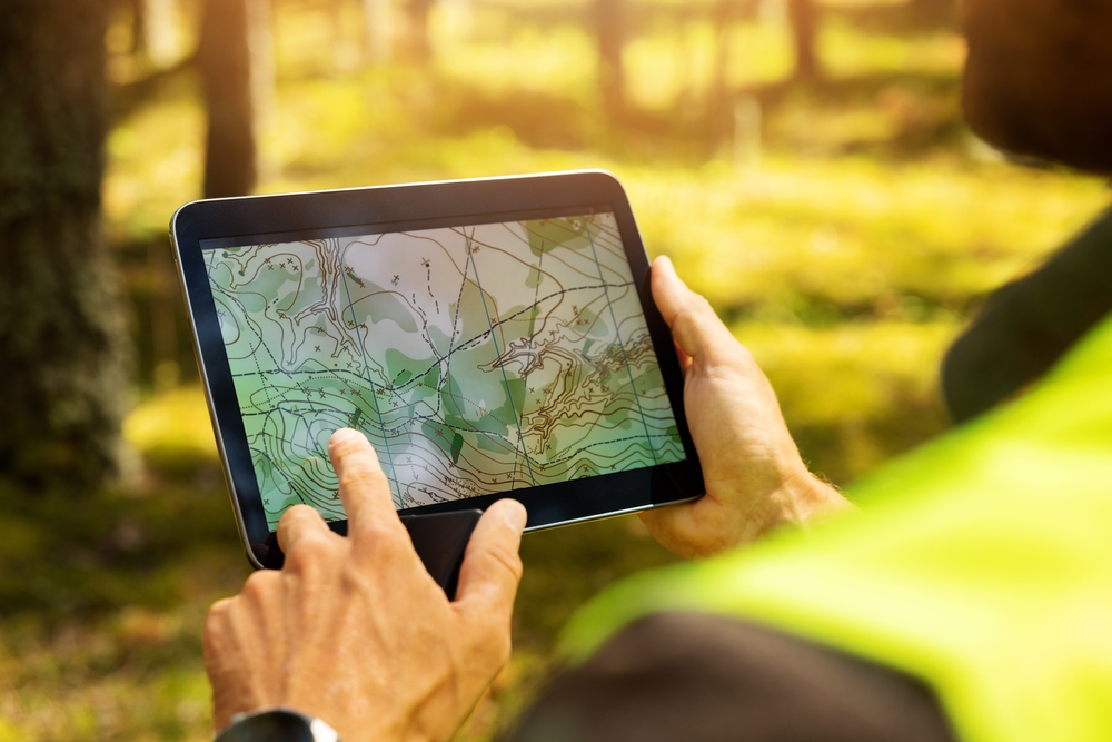 Surveyor,working,with,forest,topography,map,in,digital,tablet.,land